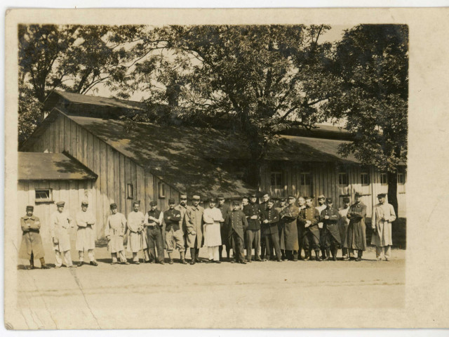 Camp de Würzburg : vue extérieure d'un groupe de prisonniers posant devant un baraquement.