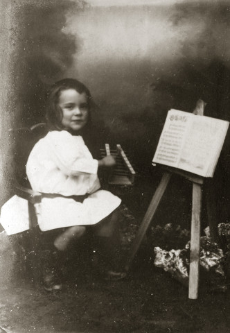 Portrait d'un jeune enfant, au xylophone, devant une partition.