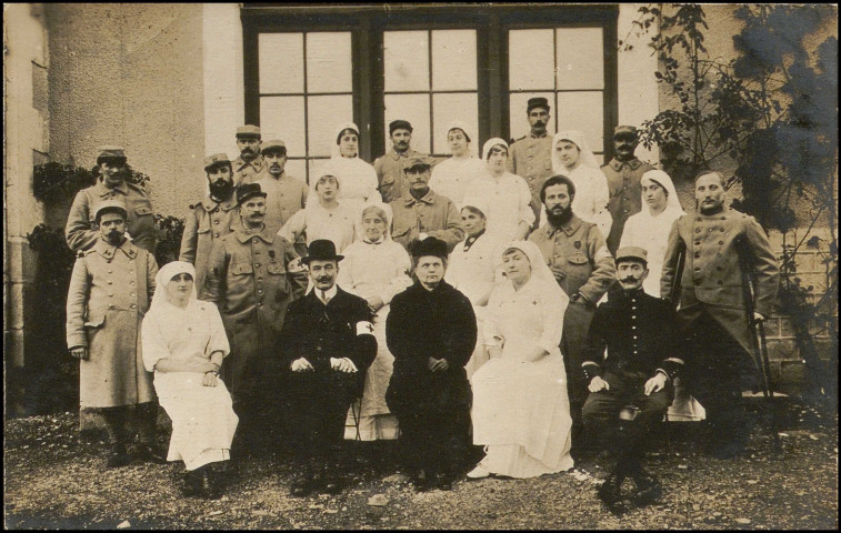 Personnel de l'hôpital et soldats devant le bâtiment.