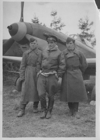 Devant un avion biplace avec deux soldats en URSS.