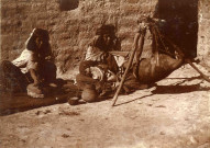 Femme mondant du blé et une autre faisant du beurre.
