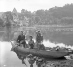 Couple et enfant en barque sur la Dordogne devant la Chapelle des Pénitents.