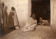 Sidi Djella, le fou, assis sur le pas d'une porte.