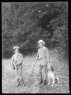 Deux enfants et un chien de chasse.