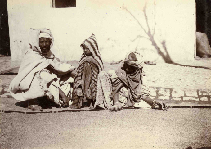Femme triant et séchant du blé avant de le monder.