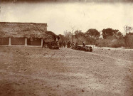 Ecole ou bâtiment collectif avec toiture en chaume, groupe aux abords.