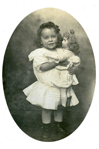 Portrait en pied d'un jeune enfant, à la poupée.