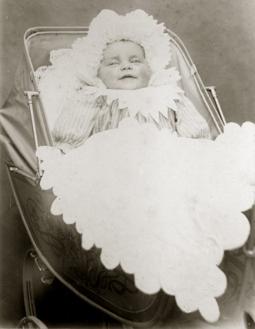 Portrait d'un bébé dans son landau.