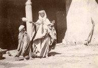 Fileuse arabe portant quenouille et un enfant.