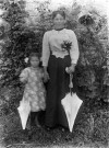 Portrait en pied : femme et enfant au jardin.