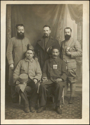 Portrait de groupe en studio de cinq soldats.