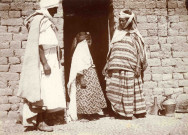 Une petite fille portant voile et tenue d'apparat, accompagnée de ses parents.