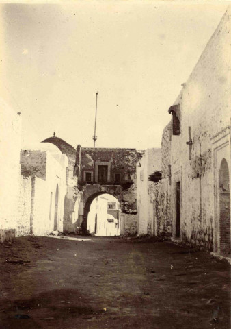 Une rue, passage sous une porte voutée.
