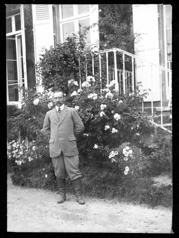 [Homme inconnu] posant devant l'escalier donnant sur la terrasse du château.