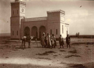 Groupe d'hommes devant une mosquée.