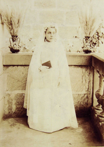 Portrait en pied d'une communiante (Marie-Lucie Montagut ?), sur un balcon.
