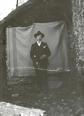 Portrait en pied d'un homme près de la remise à bois.