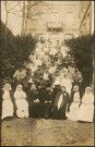 Personnel de l'hôpital et soldats devant le bâtiment.
