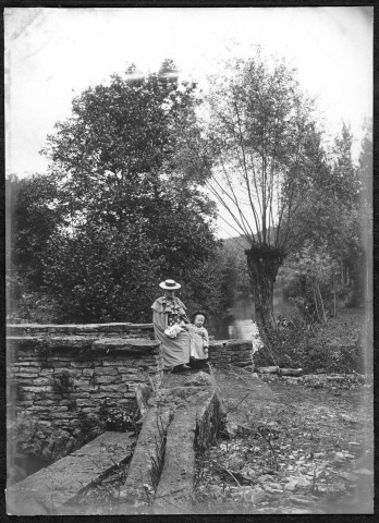 Femme et petit enfant près d'un pont.