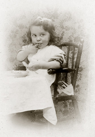 Portrait d'un jeune enfant dans sa chaise haute, le repas.