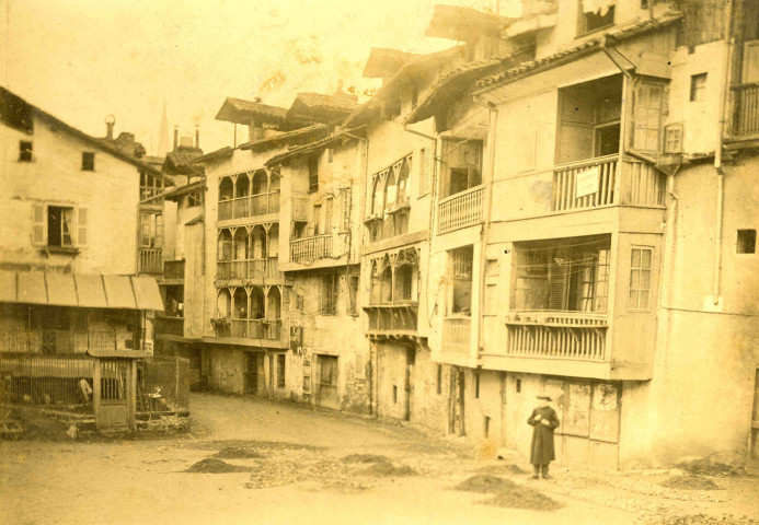 Rue de la Solane : habitat traditionnel constitué de maisons à étages avec balcons couverts.