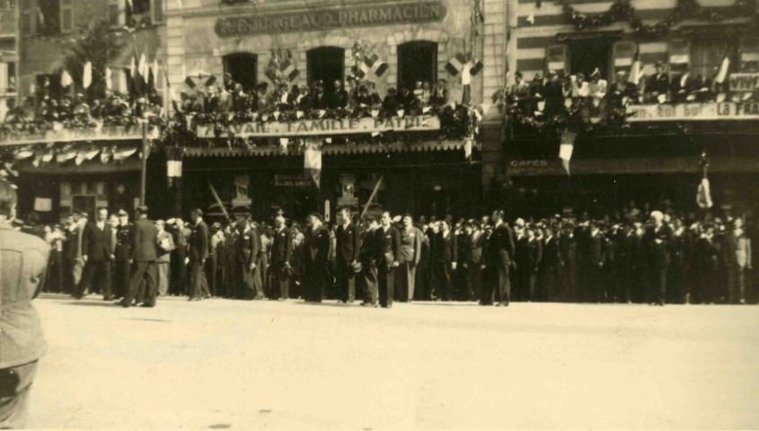 Quai Saint-Priest, devant la pharmacie Fourgeaud, la foule dans la rue et aux balcons.
