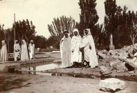 Trois notables observant un système d'irrigation.