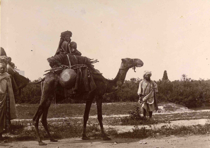Femme et enfant à dos de dromadaire.
