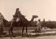 Femme et enfant à dos de dromadaire.