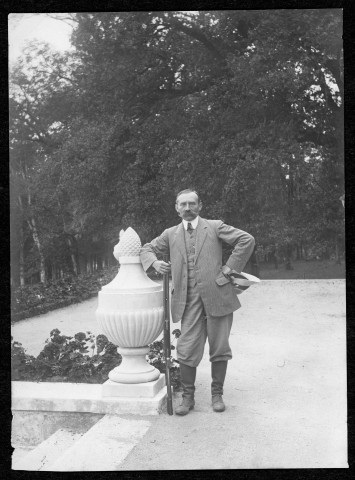 Invité du comte posant sur la terrasse du château contre un élément décoratif.