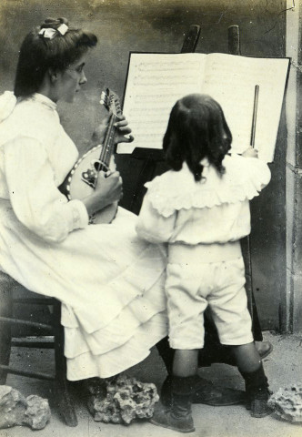Portrait d'un jeune enfant, lisant une partition, accompagné d'une jeune fille (Marie-Lucie Montagut ?) à la mandoline.