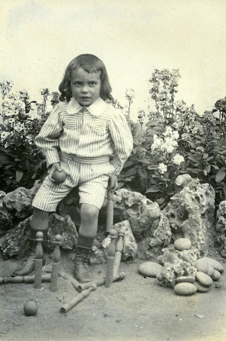 Portrait en pied d'un jeune enfant, au jeu de quilles.