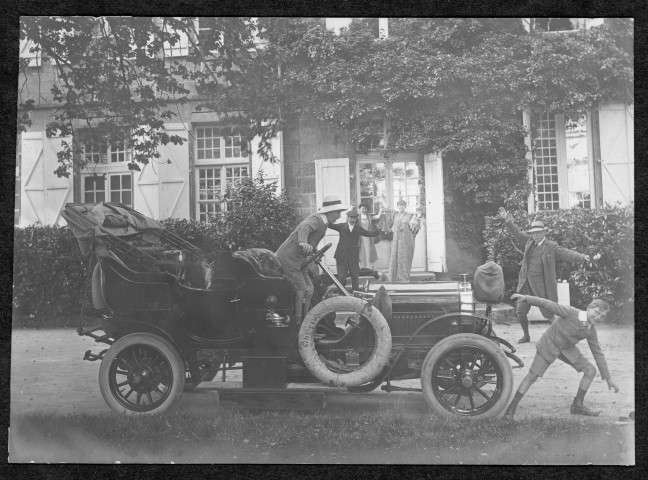 Portrait de groupe autour d'une automobile décapotée devant l'entrée principale du château.