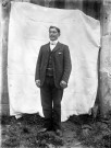 Portrait en pied d'un homme en extérieur.
