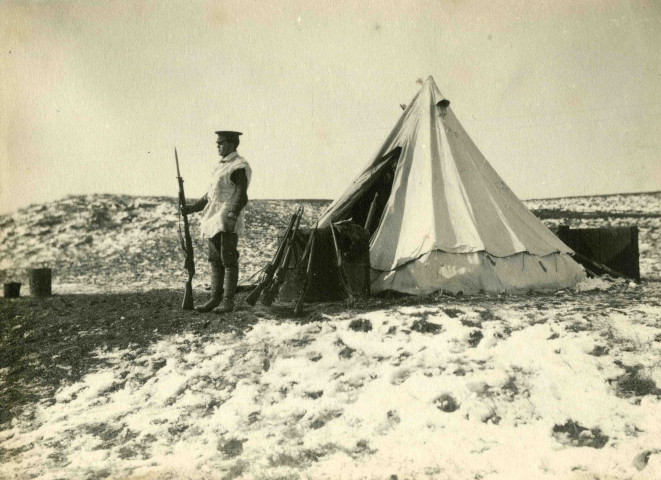 Sentinelle en poste devant une tente dans les dunes de Belgique.