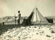 Sentinelle en poste devant une tente dans les dunes de Belgique.