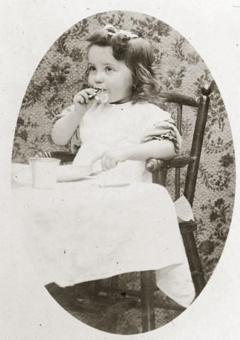 Portrait d'un jeune enfant dans sa chaise haute, le repas.