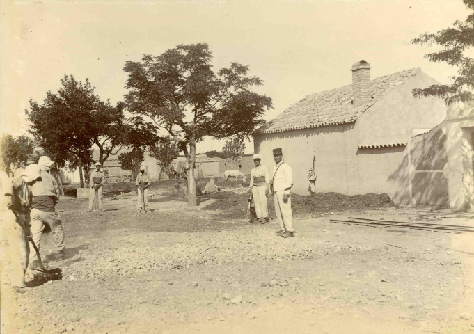 Pose d'une voie ferrée : mise en place de remblais par des soldats disciplinaires.