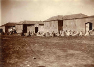 Hommes assis devant la maison du caïd.