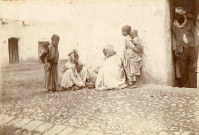 Deux hommes assis face à face dans la rue.