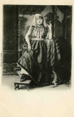 Portrait en pied de femme fumant une cigarette.