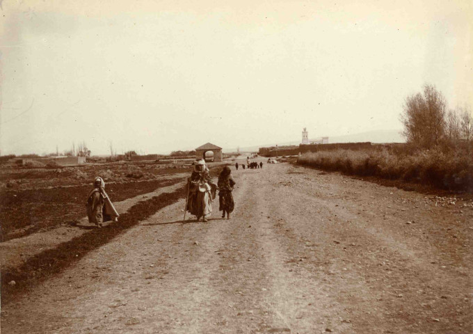 Une route se déployant à perte de vue, quelques marcheurs.
