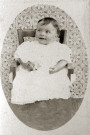 Portrait de bébé assis sur une petite chaise.