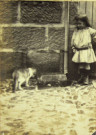 Portrait en pied d'un jeune enfant dans une cour.