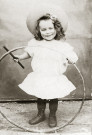 Portrait en pied d'un jeune enfant, au cerceau.